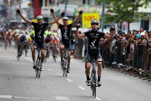 Michael Torckler crosses the line in first place during stage one of the Tour of Borneo, followed by Louis Crosby and Roman van Uden in 2nd and 3rd respectively